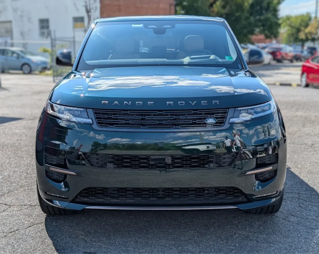 Front view of a shiny, clean dark green Range Rover Sport following professional car detailing.